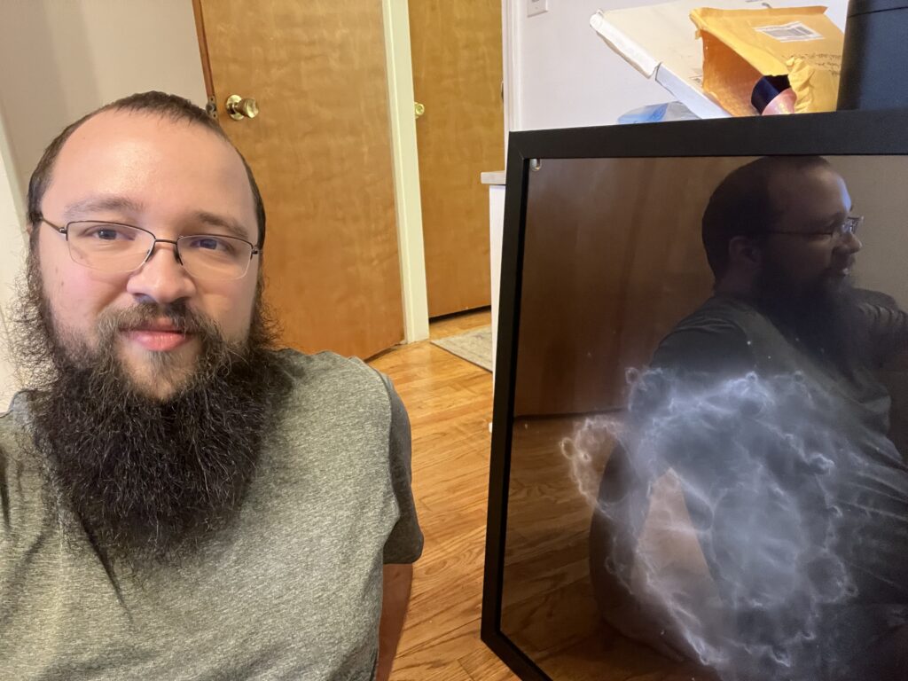 Me sitting in front of a framed poster.